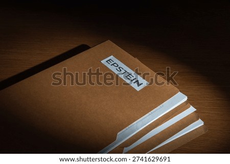 A file folder labeled EPSTEIN on a dark surface. Investigations, court documents, hidden evidence, and public scandals related to high-profile legal cases concept.