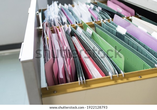 Files document of hanging file folders in a\
drawer in a whole pile of full papers, at work office, Business\
Concept Office document\
storage