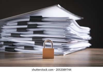 Files and documents with a padlock on the wooden table. Data security