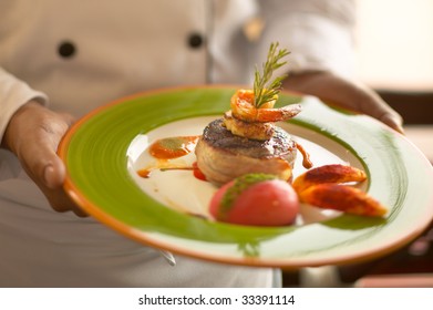 Filet Mignon Wrapped With Bacon Topped With Grilled Shrimp. Side Of Tomato And Potatoes.