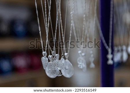Filigree silver necklace. Traditional ethnic colorful earnings jewellery over blur background and copy space, Selective focus.