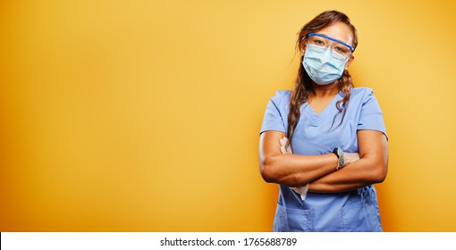 Filipina Nurse Wearing Facemask And PPE On Orange Background