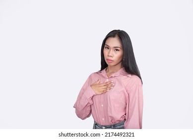 A Filipina Woman In A Pink Blouse Slightly Offended By A Rude Comment. An Emotionally Sensitive Woman. Posing Against A White Backdrop.