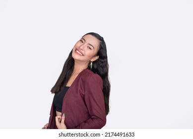 A Filipina woman showing her great personality. Side view and looking towards the camera smiling. Isolated on white background. - Shutterstock ID 2174491633