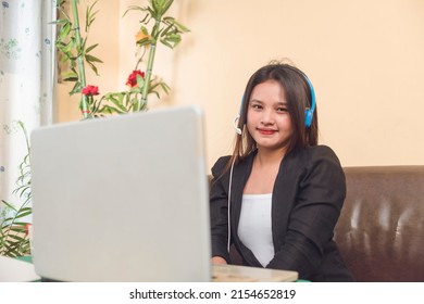 A Filipino customer service representative working remotely at her living room. A call center employee with work from home arrangement. - Shutterstock ID 2154652819