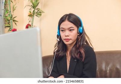 A Filipino customer service representative working remotely at her living room. A call center employee with work from home arrangement. - Shutterstock ID 2154658831