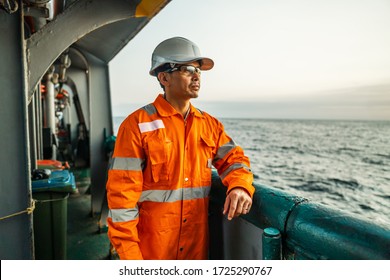 Filipino Deck Officer On Deck Of Vessel Or Ship , Wearing PPE Personal Protective Equipment - Helmet, Coverall, Lifejacket, Goggles. Safety And Work At Sea.