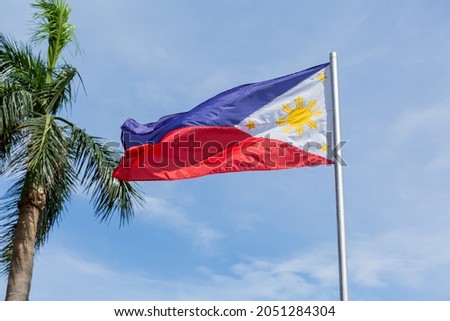 filipino national flag fluttering in the wind and sky in the rizal park in ermita