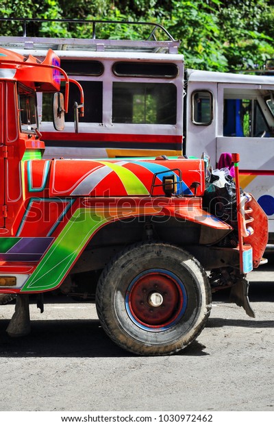 Filipino orange-red dyipni-jeepney\
car. Public transportation in Sagada town-originally made from\
US.military cars left over from WW.II locally altered-now from\
japanese surplus.\
Igorot-Philippines.