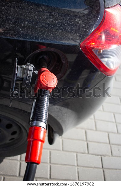 Fill the car with fuel.\
Mashunya refuel with gas at a gas station. Petrol station pump. Man\
filling up gasoline in a car while holding a nozzle. refilling the\
car