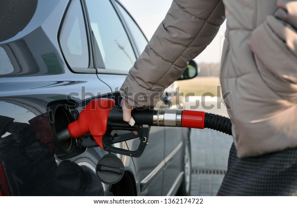 fill the car with fuel. a woman at\
a gas station with a bandaged finger is self-charging a\
car