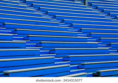 Fill the frame with the pattern from the old painted blue grandstand, a landscape image of wooden grandstand. No people in the image.