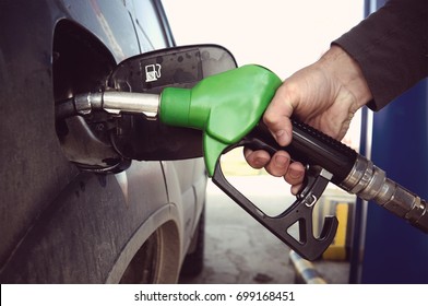 Fill Up Fuel At Petrol Station. Filling A Dirty Car At A Gas Station. Fuelling Nozzle For Refuelling A Car In Man's Hand.