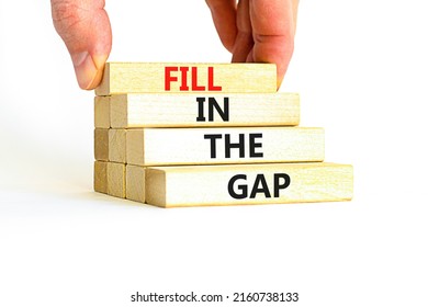 Fill in the gap symbol. Concept words Fill in the gap on wooden blocks on a beautiful white table white background. Businessman hand. Business, motivational and fill in the gap concept.