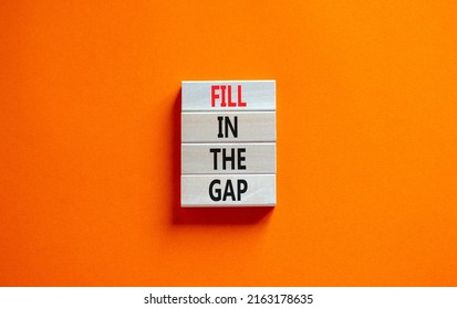 Fill in the gap symbol. Concept words Fill in the gap on wooden blocks on a beautiful orange table orange background. Business, motivational and fill in the gap concept.
