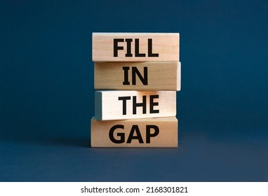 Fill in the gap symbol. Concept words Fill in the gap on wooden blocks on a beautiful grey table grey background. Business, motivational and fill in the gap concept.