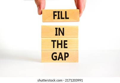 Fill in the gap symbol. Concept words Fill in the gap on wooden blocks on a beautiful white table white background. Businessman hand. Business, motivational and fill in the gap concept.