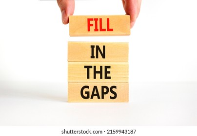 Fill in the gaps symbol. Concept words Fill in the gaps on wooden blocks on a beautiful white table white background. Businessman hand. Business, motivational and fill in the gaps concept.