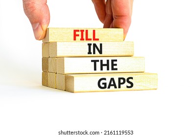 Fill in the gaps symbol. Concept words Fill in the gaps on wooden blocks on a beautiful white table white background. Businessman hand. Business, motivational and fill in the gaps concept.