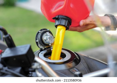 fill gasoline into a motorbike tank with a plastic gasoline tank