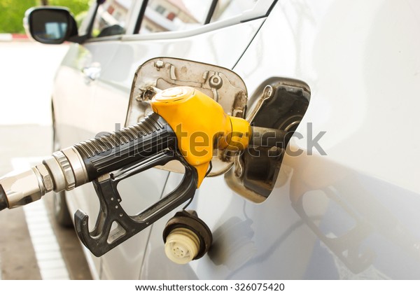 To fill the machine with fuel. Filling gasoline
to a car at a gas station.