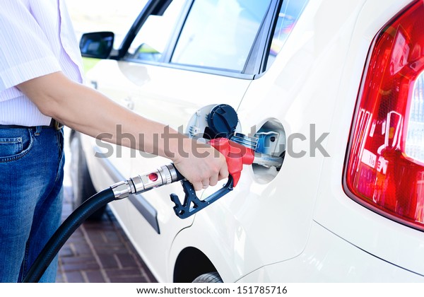 To fill the machine with fuel. Mashunya\
fill with gasoline at a gas station. Gas station pump. Man filling\
gasoline fuel in car holding nozzle. Close\
up.