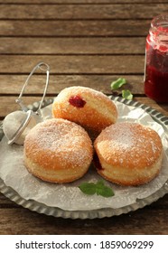 Filled Berliner Style Donuts / Doughnut With Raspberry Jam Dusted With Icing Sugar. Selective Focus On Rustic Table