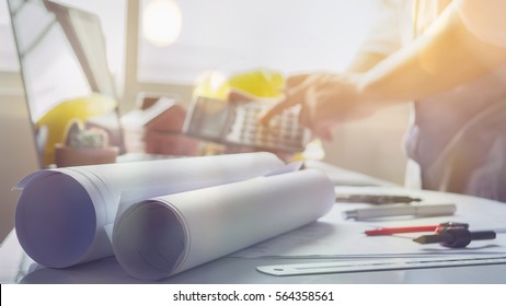 filled with building plans and background of Town planning,business man working with laptop and blueprints,landscape architects sitting  behind  the architectural business plan and calculator - Powered by Shutterstock