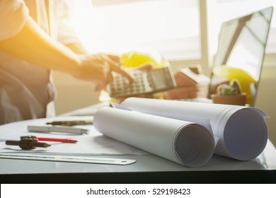 filled with building and Town planning,architect man working with laptop and blueprints, architectural plan with calculator in loft office,Building Design,selective focus. - Powered by Shutterstock