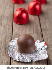 Filled Chocolate Candy With Candies Packed In Red Foil Paper.