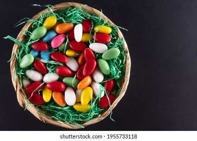 A Filled Easter Basket With Sweet Eggs On A Dark Background