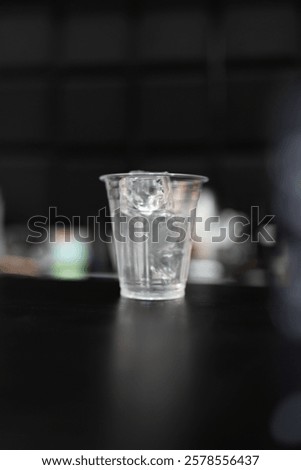 Filled with ice cubes in transparent plastic glass for a summer cold drink, cocktail, juice, coffee drink.