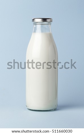 Filled milk bottle on blue.