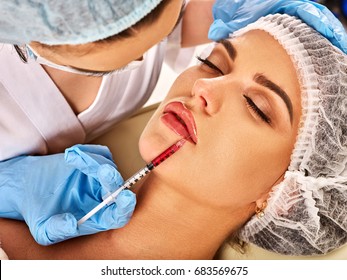 Filler injection for female forehead face. Silicone lips in the girl. Doctor in medical gloves with syringe injects lips augmentation. Plastic surgery is progressing.