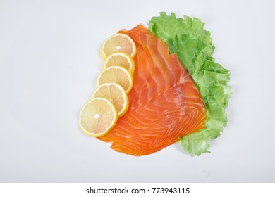 fillet of smoked red fish with lemon and herbs, isolated white background