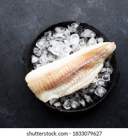 Fillet Of White Sea Cold-water Fish Cod In Ice Cubes On A Dark Background. Top View.