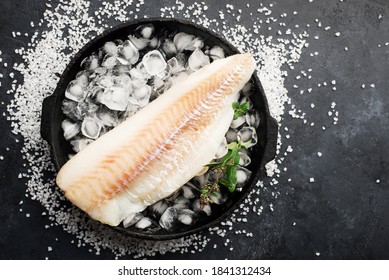 Fillet Of White Sea Cold-water Fish Cod In Ice Cubes On A Dark Background. Top View.