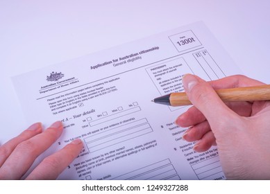 Filling Application Form 1300t For Australian Citizenship General Eligibility On White Surface. 