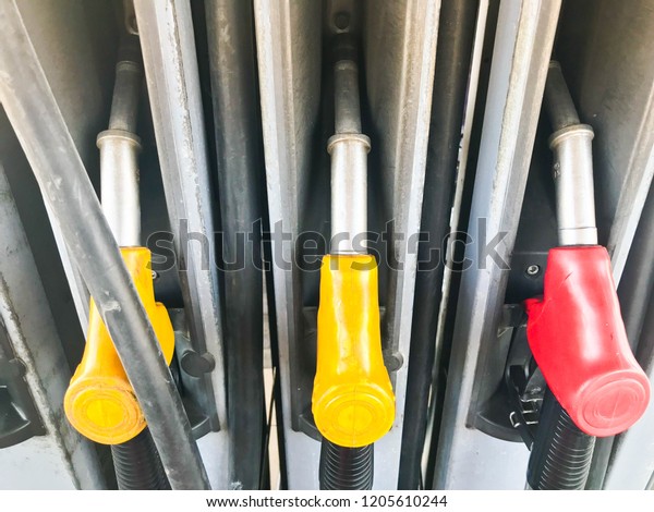 Filling colorful guns at a gas station\
for refueling a car with fuel, gasoline,\
diesel.