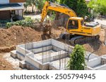 Filling the concrete foundation with soil and foundation construction with Excavator. 