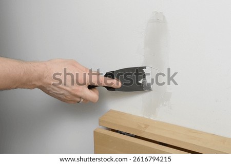 Filling a crack in the plaster, chasing plasterboard, handyman renovates the interior