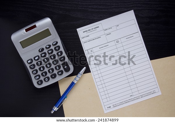 Filling the financial invoice form and calculator\
with pen.