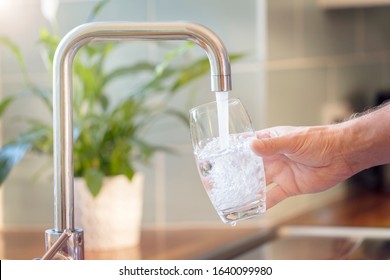 Filling Up A Glass With Clean Drinking Water From Kitchen Faucet
