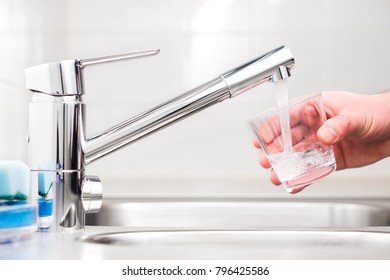 Filling Glass With Tap Water. Modern Faucet And Sink In Home Kitchen. Man Pouring Fresh Drink To Cup.