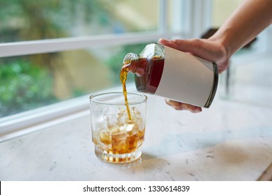 Filling Icy Glass With Cold Brew Coffee, From White Label Bottle.