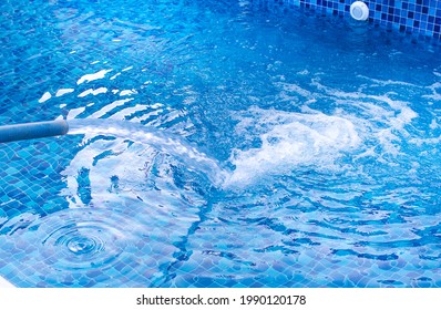 
Filling A Newly Installed Pool With Water With A Blue Hose From A Water Truck. Sensation Of Water Movement And Focus On Bubbles.