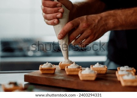 filling pastery with cream. chef prepare finger food. 