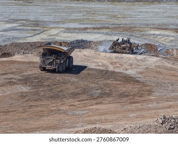 Filling and platforming process with mining trucks and bulldozer at mine dump