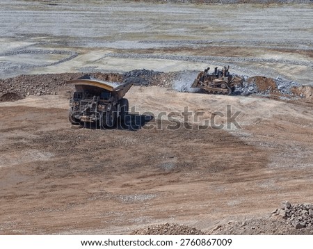 Filling and platforming process with mining trucks and bulldozer at mine dump