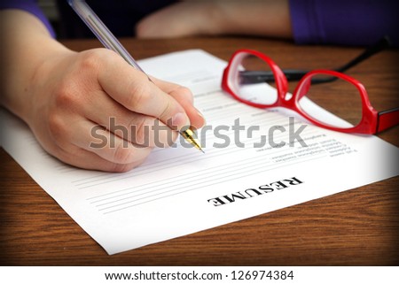 filling resume on wooden table, close-up